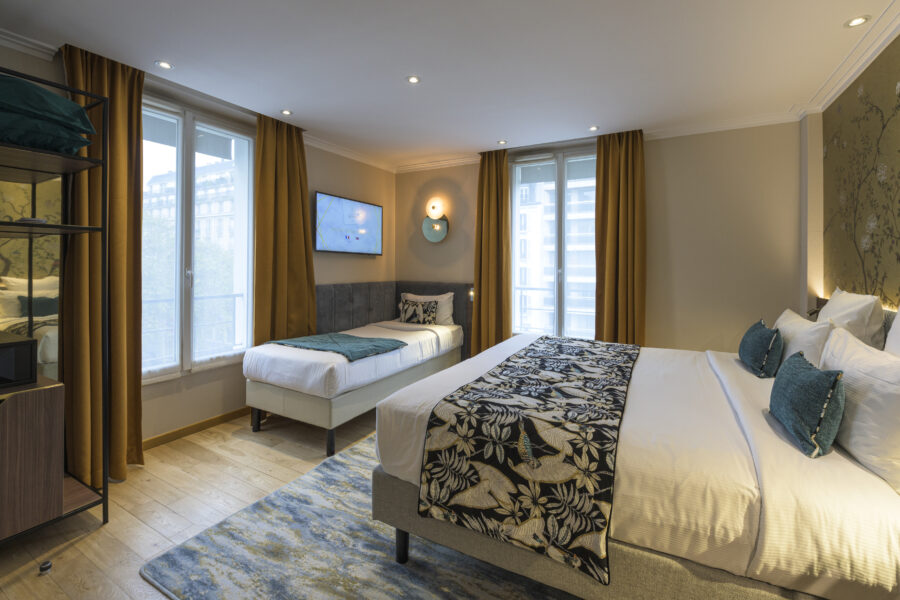 Un lit double et un lit simple en chambre supérieure Hôtel Tourisme Avenue